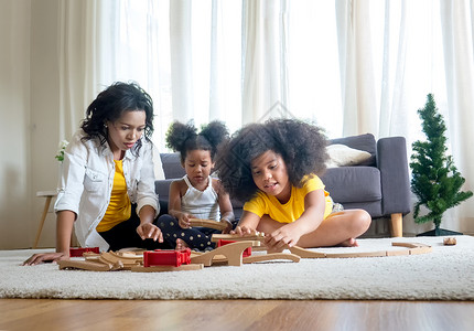 好开心家庭 父亲 母亲和女儿混合种族在客厅一起玩游戏阅读童年学生女性电脑成人乐趣教育课堂背景