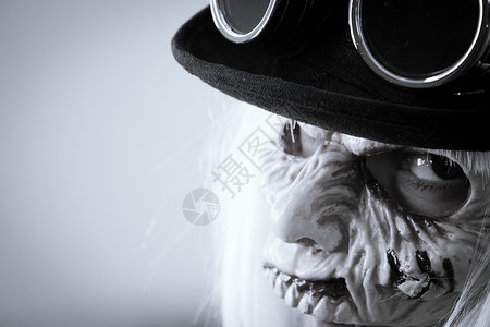 僵尸帽子有怪物脸和黑帽子 戴蒸汽桶眼镜的女人帽子镜片配饰面具金属机器女性工业古董齿轮背景
