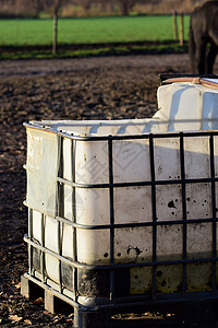 大白水大容器 用于在墙顶上的动物铁格网格黑色农业白色灰色农场太阳营养晴天背景图片