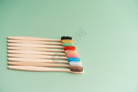 一套由浅绿色背景的竹木制成的环保抗菌牙刷 环保趋势牙医材料木头生物牙科浴室口服卫生工具牙齿背景图片