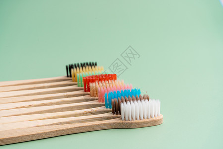一套由浅绿色背景的竹木制成的环保抗菌牙刷 环保趋势牙齿木头彩虹生态纤维口服材料工具刷子卫生背景图片