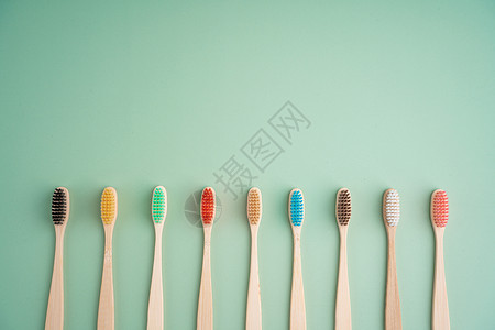 一套由浅绿色背景的竹木制成的环保抗菌牙刷 环保趋势纤维刷子材料回收工具牙科牙齿生物浴室生态背景图片
