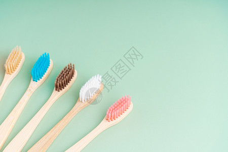 一套由浅绿色背景的竹木制成的环保抗菌牙刷 环保趋势卫生木头牙医生态牙科刷子工具浴室纤维生物背景图片