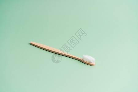 浅绿色背景的环保竹木抗菌牙刷口服卫生纤维牙齿木头牙科生态材料浴室牙医背景图片