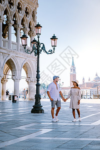 一对夫妇在威尼斯进行城市旅行 欣赏圣马可广场 意大利威尼斯总督府公爵宫的景色 威尼斯的建筑和地标 威尼斯的日出城市景观访问男人蓝背景图片