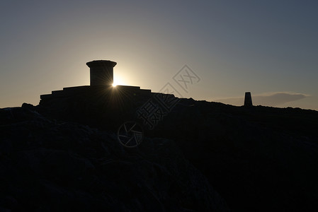 石头底座日出时在信标的望远镜后方发射太阳耀斑背景