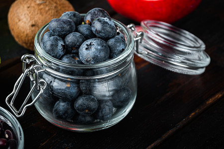 深木木背景的玻璃罐中的蓝莓木质蓝色覆盆子饮食深色浆果排毒食物背景图片