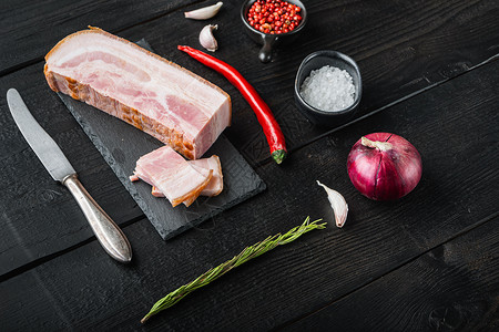 黑猪肉冷鲜在黑木制桌上用草药切碎和切片火腿猪肉乡村背景食物熏制桌子平板背景