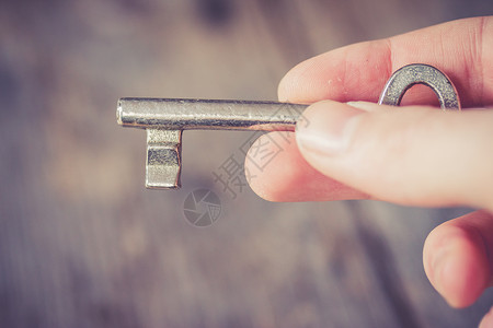 继承概念 年轻男性手中的旧钥匙密码财产魔法金属入口木头手指保护遗产男人背景图片