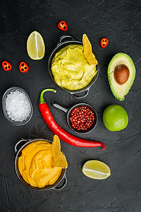 蘸酱乳瓜传统墨西哥玉米卷 黑色背景 顶视或平铺的绿色瓜卡莫菜和黄奶酪酱酱背景