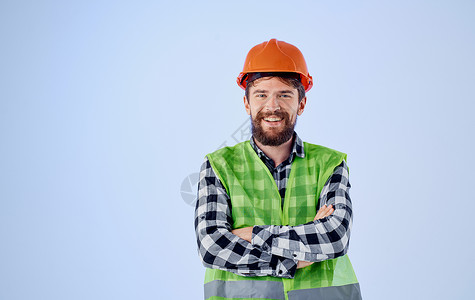 橙色格子身戴橙色硬帽的建筑工人 蓝背景和格子衬衣反射背心衬衫工作室建筑工具建造帽子承包商男人商业领班背景