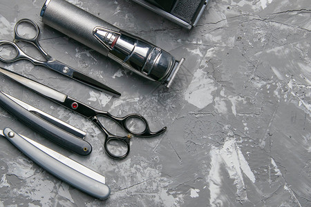黑色背景上的理发店设备 带有文本位置 专业美发工具 梳子 剪刀 剪刀和理发器背景图片