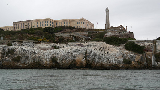 美国加利福尼亚州旧金山湾的恶魔岛 在岩石上关押歹徒的联邦监狱 多雾的天气 历史悠久的监狱 迷雾笼罩的海港悬崖 犯罪入狱帆船力量阴背景图片