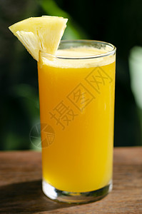 新鲜的有机菠萝汁 在户外餐桌上菠萝水果果汁玻璃杯花园晴天玻璃桌子背景图片