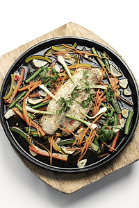 中国风格的中国式蒸鱼片 热盘上加蔬菜电炉美食香料热板推介会食物草药鱼片白色背景图片