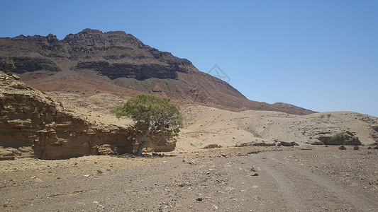 穿过沙漠的碎石路天空岩石石头爬坡公路高清图片