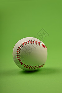 将一个棒球球特写在绿色白色红色存货场地运动背景图片
