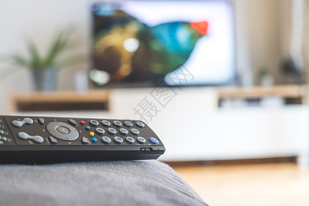 高清素材节目在沙发上的遥控器 流到智能电视上溪流点播屏幕控制板遥控家庭客厅按钮影院电视节目背景