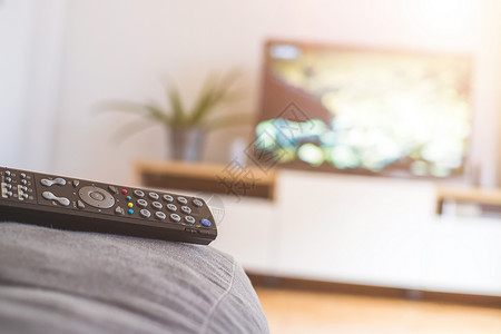 高清素材节目在沙发上的遥控器 流到智能电视上影院遥控娱乐渠道卫星电视节目屏幕展示按钮程序背景