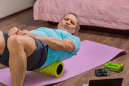 50岁的男子在家里的垫子上做操练 看电脑 25岁成年动机身体闲暇力量护理有氧运动专注福利男性背景图片