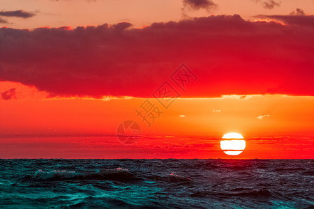 海面的浪漫日落射线游艇天空紫色橙子太阳帆船蓝色海洋戏剧性背景图片