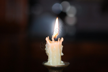 白蜡烛火焰中间一个烛台上的白蜡烛背景