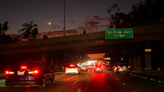 三车道夜间从车上看 洛杉矶繁忙的高速公路在夜间 美国加利福尼亚州的大型州际公路 自动在高速公路车道上快速行驶 交通堵塞和城市交通概念旅行沥背景