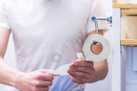 厕所概念 男性手拉卫生纸 关上房间消化道衣架粪便男人卫生疼痛配饰浴室清洁度背景图片