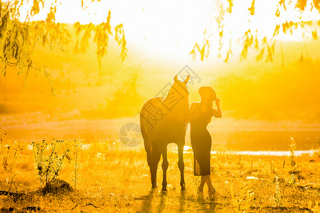 日落时 女孩和马在散步高清图片