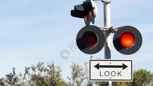 减速慢行注意行人美国的平交道口警告信号 加利福尼亚州铁路路口的 Crossbuck 通知和红色交通灯 铁路运输安全标志 关于危险和火车轨道的警告背景