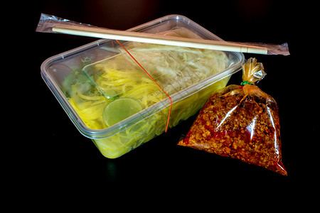 带酱汁的意大利面条 用塑料包装将食物带回家托盘盒子筷子美食红色背景图片