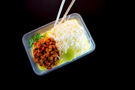 带酱汁的意大利面条用塑料包装将食品带回家红色盒子蔬菜托盘美食背景图片