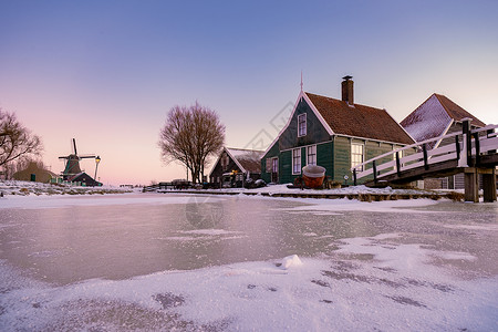 荷兰村的风车雪 冬季历史上的木制风车天空反射农村村庄蓝色建筑传统建筑学桑色旅游背景图片