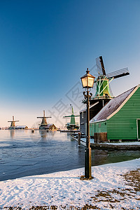 荷兰村的风车雪 冬季历史上的木制风车房子建筑学天空传统农村国家建筑历史性博物馆旅游背景图片