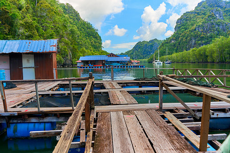 码头小屋马来西亚兰卡维岛的一个浮游渔场 位于马来西亚的Langkawi岛上渔夫木头蓝色旅行工作天空热带小屋旅游假期背景
