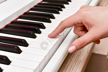 熟能生巧女人的手在家里弹电子数码钢琴 这位女士是专业钢琴家 使用钢琴电子键盘编曲 练习键盘作曲的音乐家工作室作品教育按钮旋律乐器艺术家琴背景