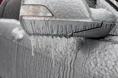 汽车霜冷冻后视镜和有冰冰 冰和霜的汽车擦拭器背景