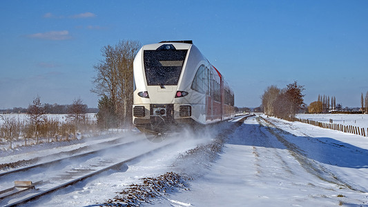 冬季从荷兰出发 在农村开火车去乘火车骑术运输速度天气铁轨驾驶铁路糖霜旅行白色背景图片