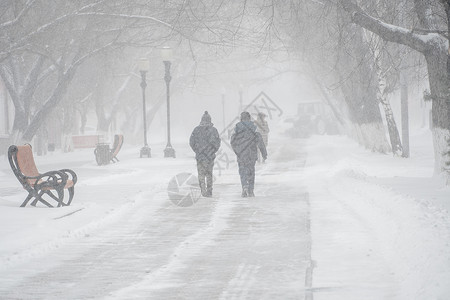 气旋风暴一条积雪覆盖的道路 冬天在城市的恶劣天气下 人们在暴风雪 暴风雪或降雪中 北方的极端冬季天气条件 人们在大雪中穿过街道民众气象气背景