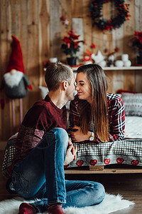 女孩和圣诞节一个男人和一个女孩一起庆祝新年 并互相赠送礼物给对方幸福喜悦地毯衬衫拥抱蜡烛微笑绿色红色青年背景