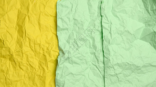皱巴巴的黄色和绿色纸片背景图片