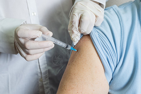 一名老年白人男子在疗养院接受一剂疫苗接种注射器长老退休人员护士疾病药品手套手术病人背景图片