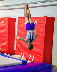 体操双杠年轻人在训练中跳跃过空 在训练中背景