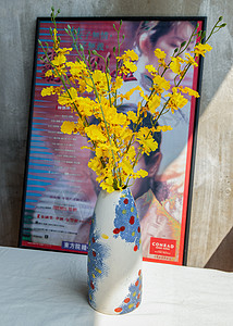 家居装饰海报手工陶瓷花瓶中的黄花与中国古典海报电影框与旧遗址水泥墙陶器艺术工艺制品潮人热情家居花束建筑学装饰背景