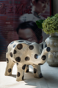 陶瓷艺术海报中国古典海报电影框前白色质感桌布上陶瓷花瓶中大象形陶瓷和花束背景