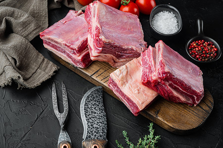 大理石纹肉以黑石为背景 配有原料的炖菜中短骨背景