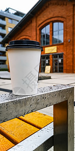 板凳上水杯雨天台板凳湿扶轮上的咖啡纸杯背景