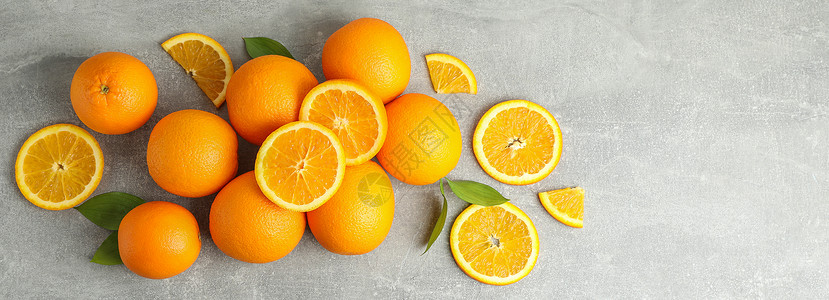 橘子熟了许多熟熟橙子 灰色桌上有叶子派对热带蓝色作品排毒树叶水果食物饮食橘子背景