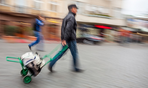中年人带着手提包的马车白色商业水平旅行活动跑步手雕城市成人黑色背景图片