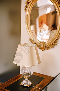 古老的古董桌灯 有白色灯罩和晶体底 古董镜像在金框中风格蜡烛桌子白炽灯床头水晶装饰玻璃黄铜背景图片